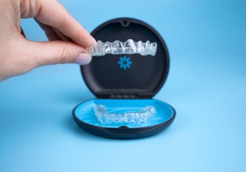 Woman,Holding,Invisalign,Transparent,Retainers,With,A,Box,On,The